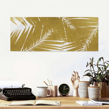 Glasbild - Blick durch goldene Palmenblätter - Panorama